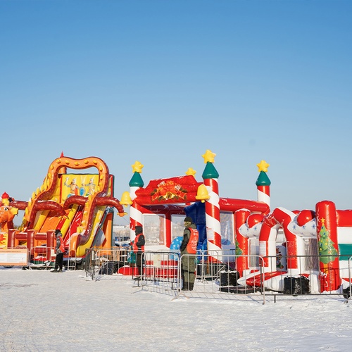 Надувной новогодний городок: батуты, горки и игровые модули на снегу